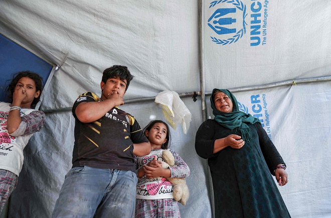 نهيا عيسى ، عراقية تبلغ من العمر 33 عامًا ، وقد نزحت من الموصل ، تقف مع أفراد أسرتها في خيمة في مخيم الخازر للنازحين داخلياً