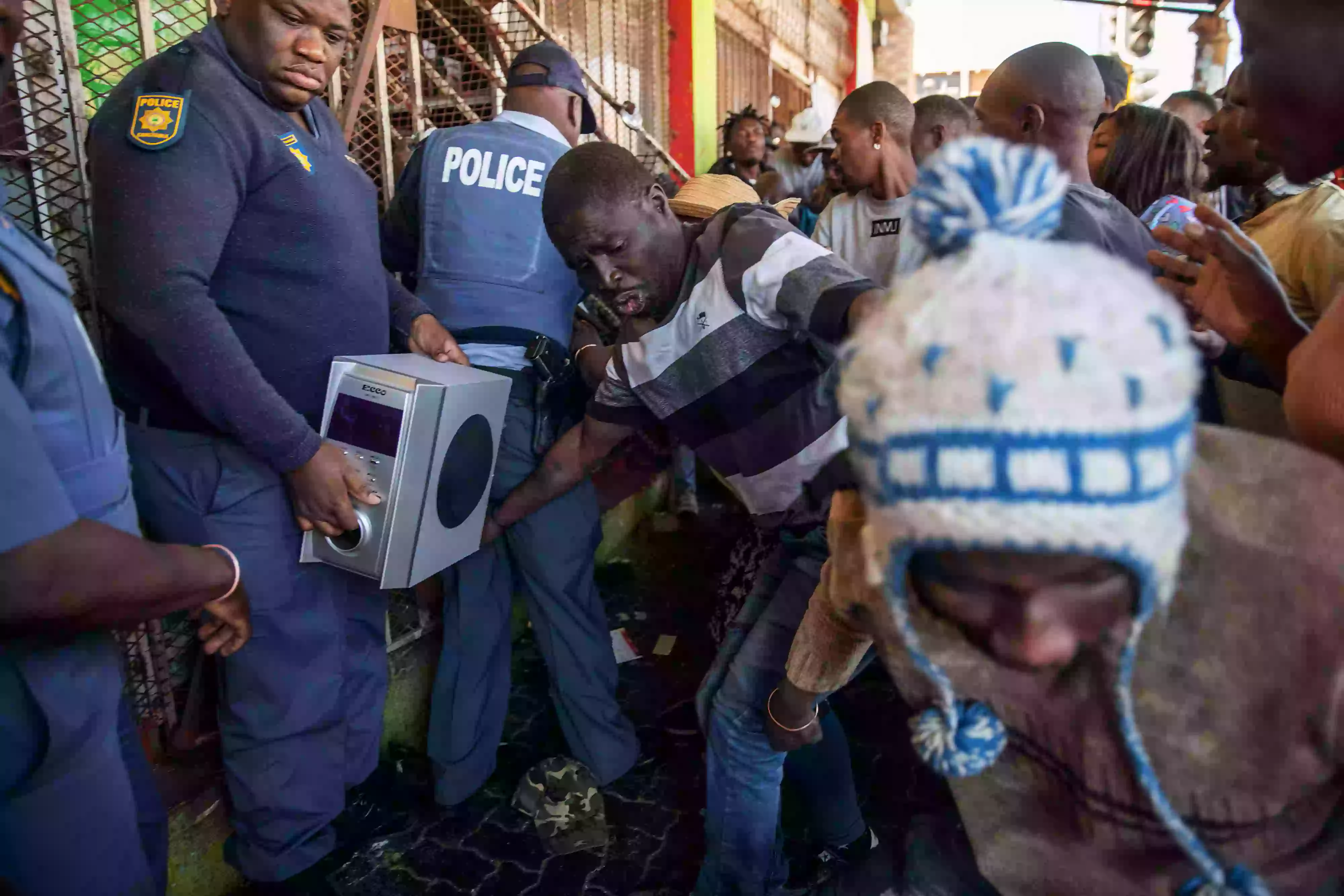 يحاول أفراد من شرطة جنوب إفريقيا إيقاف اللصوص من الدخول للمتجر