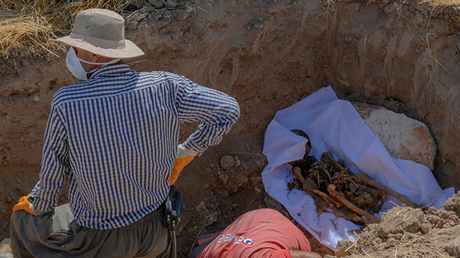 عمال يحفرون جثة سيتم نقلها من المقبرة القديمة إلى مقبرة حسانكيف الجديدة