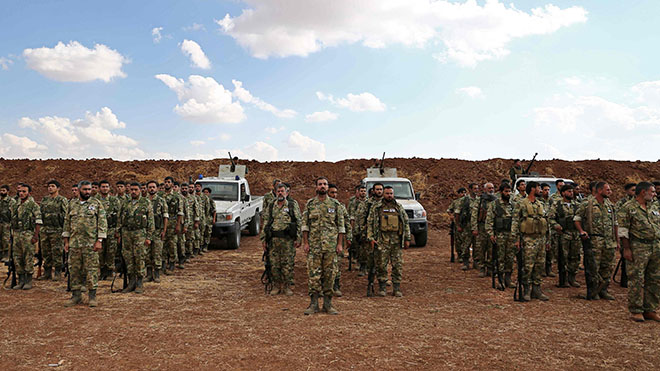 تجمع المقاتلون السوريون المدعومون من تركيا بالقرب من الحدود السورية التركية خلال انسحاب القوات الأمريكية