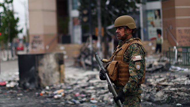 جندي يقف أمام متجر بعد اقتحامه ونهبه من قبل المتظاهرين