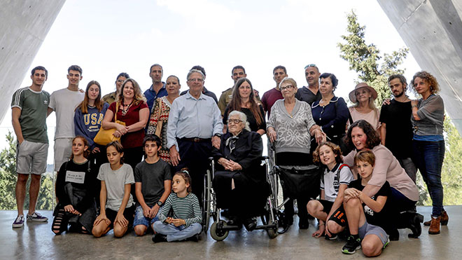 صورة جماعية تُظهر المُنقذة اليونانية مع الأشخاص الذين أنقذتهم وعائلاتهم