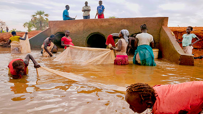 لاجئون ومجتمع مضيف محلي يصطادون في مجرى يتكون من فيضانات شديدة في مابان بجنوب السودان