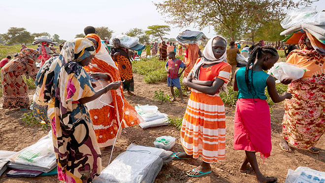 يقوم أفراد المجتمع المضيف المحلي بتأمين المواد المنزلية الطارئة التي تم توزيعها للتو ، مثل الصابون والبطانيات وأحواض الغسيل ، عقب الفيضانات الشديدة في مابان ، جنوب السودان