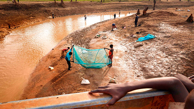 سكان مخيم يوسف بطير للاجئين يصطادون مع المجتمع المضيف المحلي في مجرى تشكل نتيجة للفيضانات الشديدة في مابان ، جنوب السودان