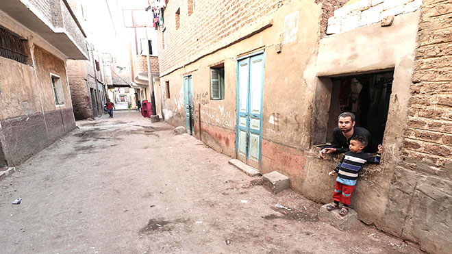 البقال المصري محمد مصطفى ، 31 عاماً ، يطل من نافذة متجره في قرية النحية ، أحد أفقر البلاد ، في محافظة أسيوط بوسط مصر