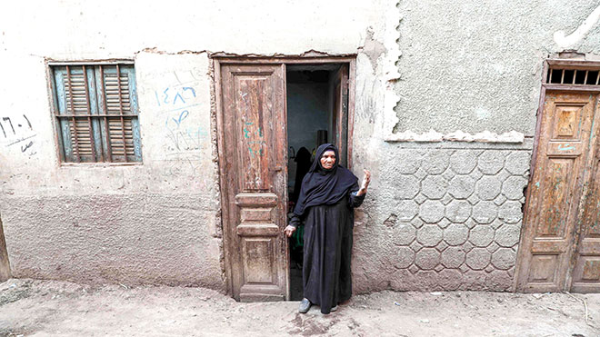 المصرية هانم الزناتي ، 75 عامًا ، تقف عند باب منزلها في قرية النحية ، أحد أفقر البلاد ، في محافظة أسيوط بوسط مصر