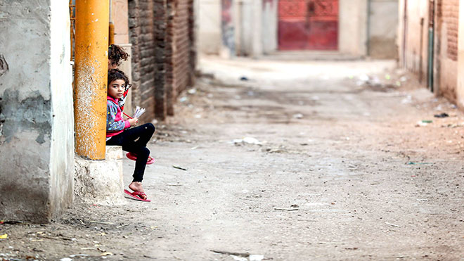 أطفال مصريون يجلسون على جانب زقاق في قرية النحية ، أحد أفقر البلاد ، في محافظة أسيوط بوسط مصر