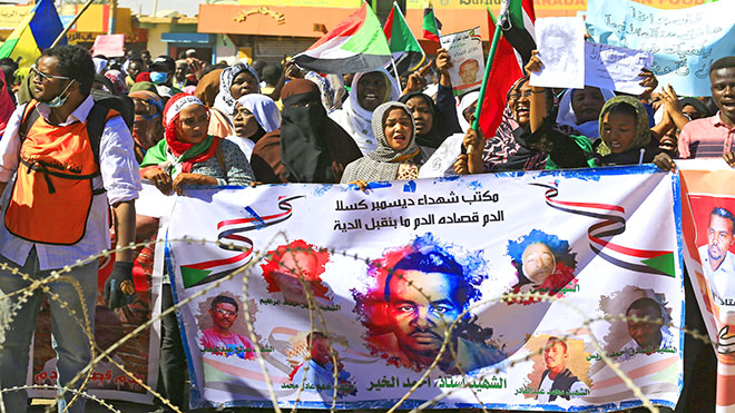 المتظاهرون في شوارع رئيسية وهم يحملون أعلام السودان ولافتات