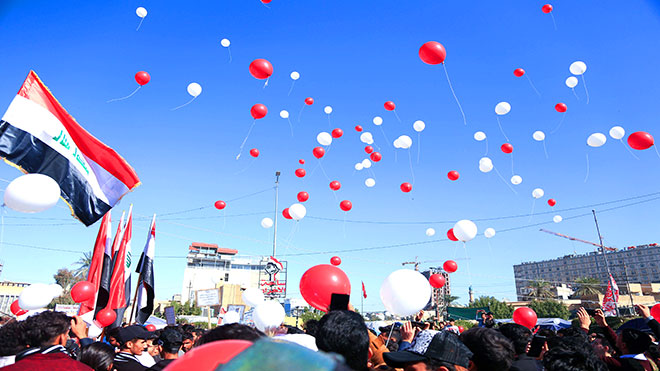 طلاب عراقيون يرفعون بالونات أثناء مشاركتهم في المظاهرات المستمرة المناهضة للحكومة في مدينة كربلاء بوسط العراق