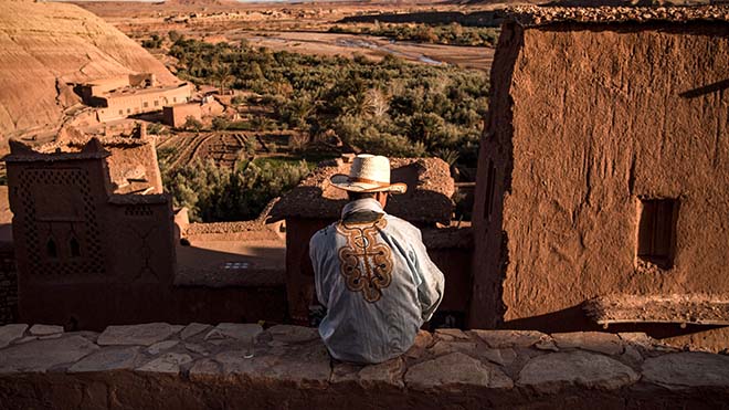 رجل يجلس على قمة قصبة آيت بن حدو (القصبة القديمة) ، حيث تم تصوير مشاهد تصور مدينة Yunkai الخيالية من سلسلة HBO التلفزيونية الشهيرة Game of Thrones