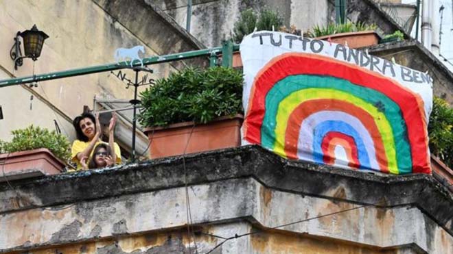 إيطاليون يلوحون بجوار لافتة تقول: "كل شيء سيكون على ما يرام"