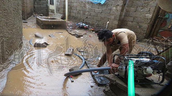 مواطن يقوم بشفط مياه الأمطار