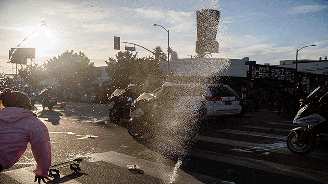 المتظاهرون يرمون زجاجات المياه في سيارة LAPD في لوس أنجلوس
