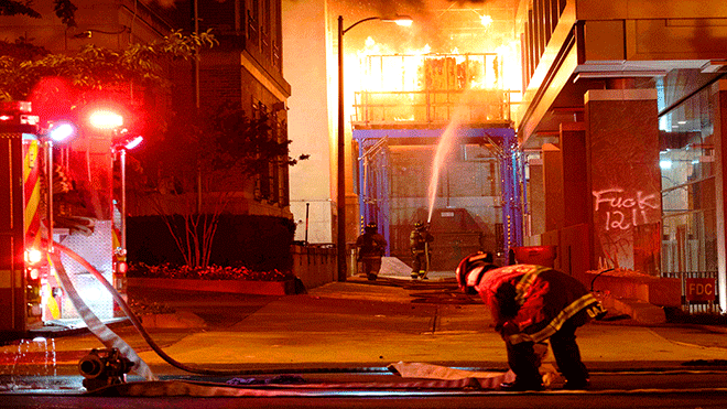 يعمل رجال الإطفاء لإخماد حريق سقالة البناء ، بدأه المتظاهرون ، على بعد مبنى واحد من البيت الأبيض