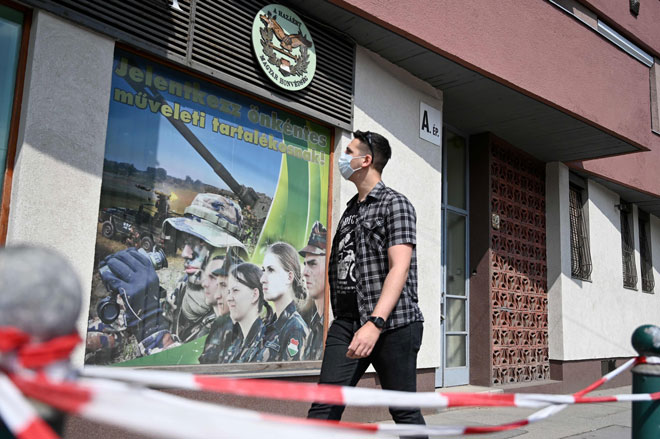 رجل يرتدي قناع وجه عند وصوله للتقدم للحصول على وظيفة في مكتب تجنيد قوات الدفاع المجرية في بودابست