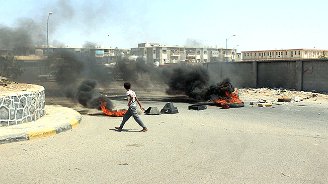 محتجون بلحج يحرقون إطارات السيارات ويقطعون الطريق
