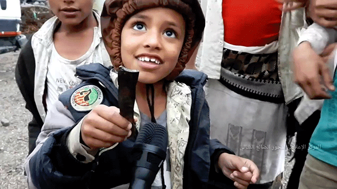 طفلة يحمل بيده شظايا مقذوفات الهاون