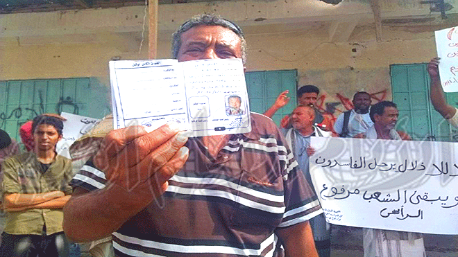 مواطن يحمل دفتر معاش خلال الوقفة الاحتجاجية
