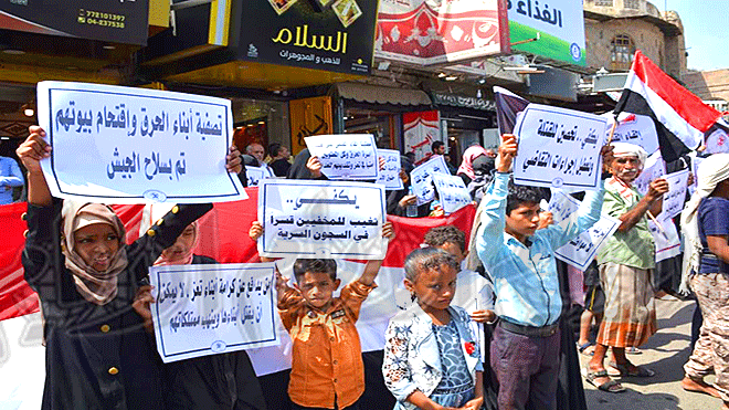 أطفال مشاركون يحملون لافتات بالجريمة التي تعرضت لها أسرة الحرق