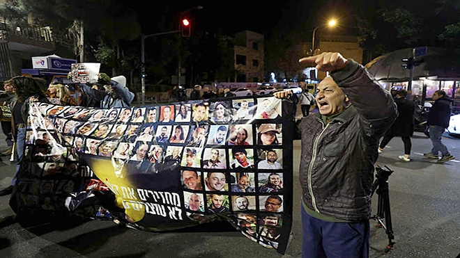 محتجون يحملون يافطه عليها صور أسراهم أمام مقر إقامة رئيس الوزراء بنيامين نتنياهو