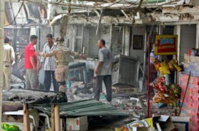 جندي عراقي يقوم بابعاد المدنيين الوقفين امام حطام المطعم