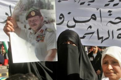 امرأة اردنية تحمل صور للملك عبدالله الثاني في مظاهرة يوم امس