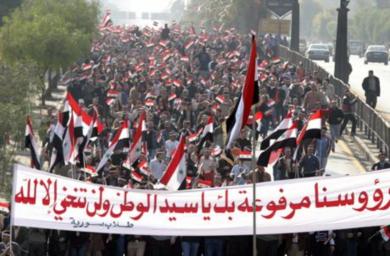 متظاهرون يحملون الافته كتب عليها "رؤوسنا مرفوعة بك ياسيد الوطن ولن تنحني الا لله"