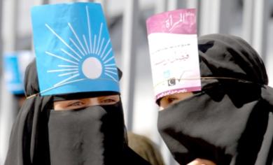 فتاة تضع على رأسها رمز الإصلاح وأخرى رمزاً لمناصرة المرأة مرشح المشترك في المهرجان الانتخابي امس