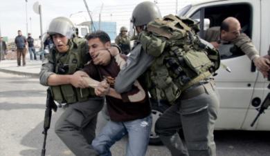 جنديان اسرائيليان يعتقلوا احد المتظاهرين الفلسطينيين
