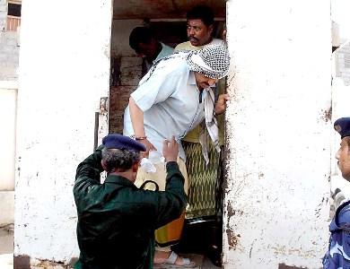 المتهم أثناء نزوله من سيارة السجن المتهم أثناء نزوله من سيارة السجن