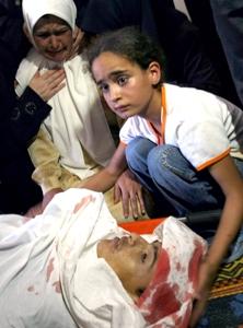 طفلة فلسطينية بجانب جثة أخيها أحمد العبادلة (20 عاما) قبل جنازته يوم أمس وهو أحد أربعة فلسطينيين قتلتهم القوات الاسرائيلية أمس في غزة بعد اشتباك مسلح طفلة فلسطينية بجانب جثة أخيها أحمد العبادلة (20 عاما) قبل جنازته يوم أمس وهو أحد أربعة فلسطينيين قتلتهم القوات الاسرائيلية أمس في غزة بعد اشتباك مسلح