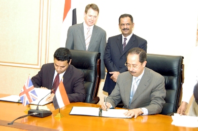 الوزير عبدالكريم الأرحبي والوزير البريطاني شهيد مالك يوقعان على الاتفاقية بينما يقف خلفهما رئيس الوزراء والسفير البريطاني الوزير عبدالكريم الأرحبي والوزير البريطاني شهيد مالك يوقعان على الاتفاقية بينما يقف خلفهما رئيس الوزراء والسفير البريطاني