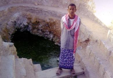 عبدالله بانجار من ابناء المنطقة يقف عند احد العيون عبدالله بانجار من ابناء المنطقة يقف عند احد العيون