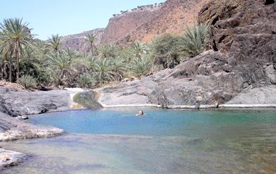 سائح يسبح في بركة لمياه صخرية طبيعية سائح يسبح في بركة لمياه صخرية طبيعية