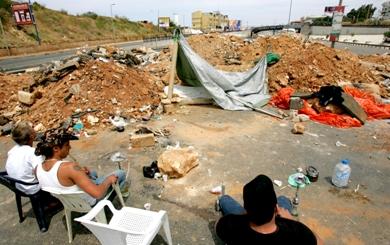 مقاتلون من حزب الله يدخنون الشيشة في نقطة إغلاق الطريق الرئيس المؤدي إلى مطار بيروت الدولي أمس مقاتلون من حزب الله يدخنون الشيشة في نقطة إغلاق الطريق الرئيس المؤدي إلى مطار بيروت الدولي أمس