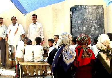 طلاب يدرسون تحت الخيم ويظهر مدير المدرسة في الوسط طلاب يدرسون تحت الخيم ويظهر مدير المدرسة في الوسط