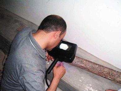 الخبير جمال الجابر يفحص بجهاز خاص قطعة بمنبر شبام الخبير جمال الجابر يفحص بجهاز خاص قطعة بمنبر شبام