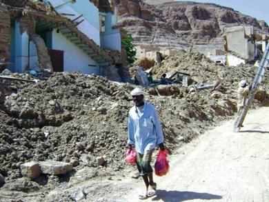 حياة اعتيادية.. مواطن يحمل أغراض يومية يعبر في شارع مدمر حياة اعتيادية.. مواطن يحمل أغراض يومية يعبر في شارع مدمر