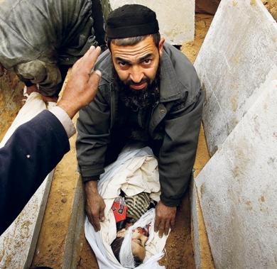 فلسطيني يقوم بدفن الشهيد صدقي العبسي (5 سنوات) في مقبرة رفح أمس فلسطيني يقوم بدفن الشهيد صدقي العبسي (5 سنوات) في مقبرة رفح أمس