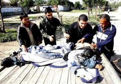فلسطينيون يضعون جثامين شهداء على عربة حصان إثر غارة إسرائيلية على حي الزيتون بمدينة غزة أمس فلسطينيون يضعون جثامين شهداء على عربة حصان إثر غارة إسرائيلية على حي الزيتون بمدينة غزة أمس
