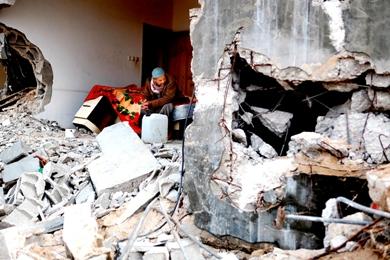 فلسطيني يجلس على سرير وسط منزله المهدم في غزة الجريحة فلسطيني يجلس على سرير وسط منزله المهدم في غزة الجريحة