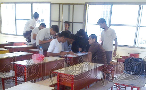 مشرفة تقوم بمساعدة الطلاب على حل اسئلة الامتحانات مشرفة تقوم بمساعدة الطلاب على حل اسئلة الامتحانات