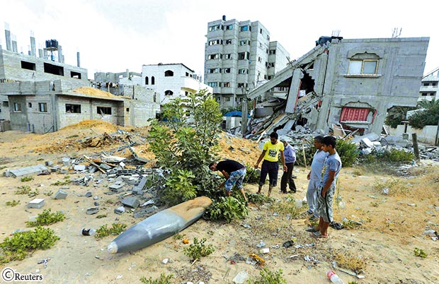 فلسطينيون ينظرون إلى قذيفة يقول شهود إنها أطلقت من طائرة عسكرية إسرائيلية فلسطينيون ينظرون إلى قذيفة يقول شهود إنها أطلقت من طائرة عسكرية إسرائيلية
