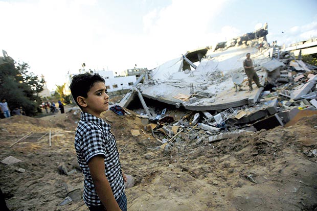 صبي فلسطيني يقف بجانب منزل دمرته غارة جوية إسرائيلية على بيت لاهيا شمال غزة صبي فلسطيني يقف بجانب منزل دمرته غارة جوية إسرائيلية على بيت لاهيا شمال غزة