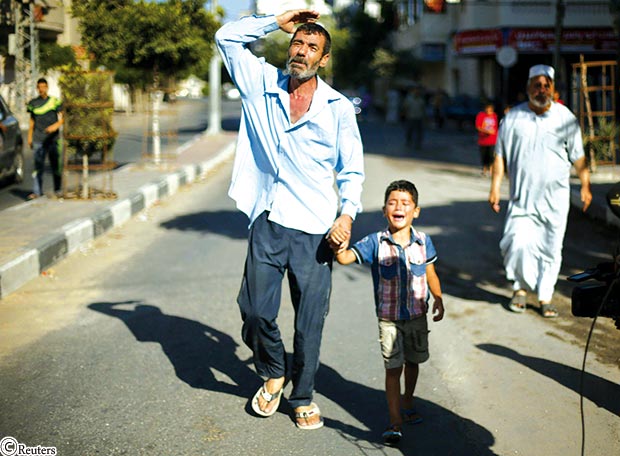 والد أحد الأطفال القتلى مع شقيق القتيل خلال الجنازة أمس والد أحد الأطفال القتلى مع شقيق القتيل خلال الجنازة أمس