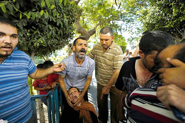 والد ووالدة أحد الأطفال القتلى خلال الجنازة أمس والد ووالدة أحد الأطفال القتلى خلال الجنازة أمس