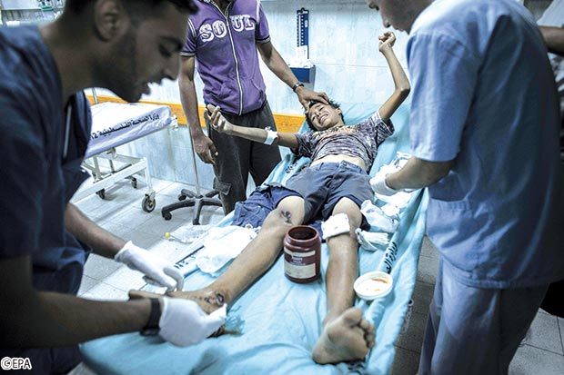 أطباء في بيت لاهيا يعالجون صبيا فلسطينيا ) 9 سنوات( أصيب بها بعد غارة جوية إسرائيلية أطباء في بيت لاهيا يعالجون صبيا فلسطينيا ) 9 سنوات( أصيب بها بعد غارة جوية إسرائيلية