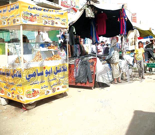 باعة يعرضون مبيعاتهم على الخط العام للمدينة باعة يعرضون مبيعاتهم على الخط العام للمدينة