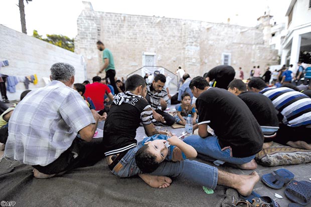 شباب فلسطينيون يفطرون في أحد الملاجئ بقطاع غزة